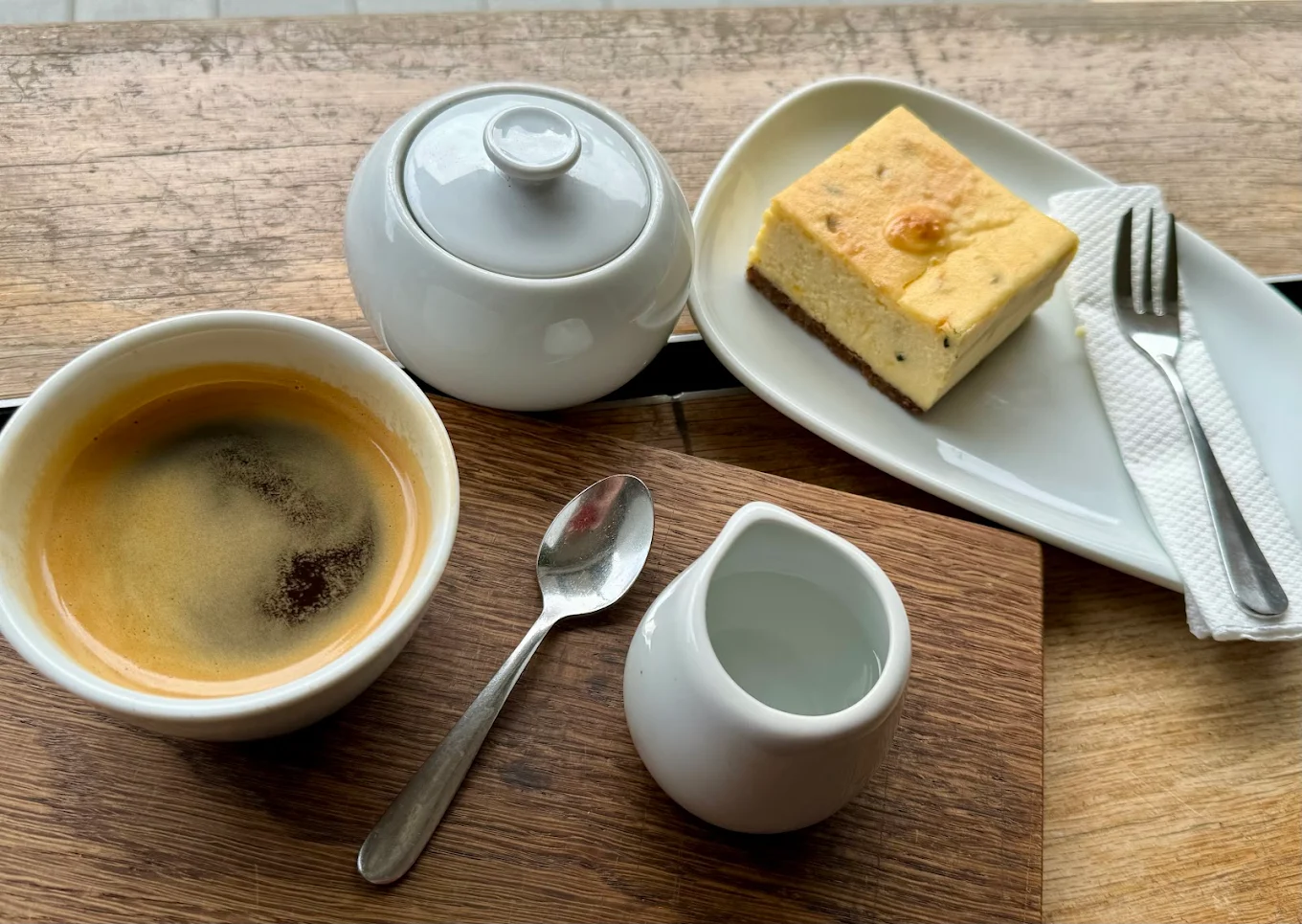 Long black coffee and passionfruit cheesecake on a timber table